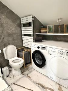 uma casa de banho com uma máquina de lavar roupa e um WC em Magnifique Appartement Neuf, 5 Min Orly - Climatisé em Paray-Vieille-Poste