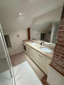 a bathroom with two sinks and a large mirror at Spacious 4 bed family home near coast in North Creake