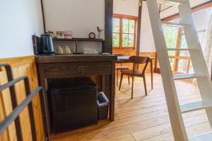 a kitchen with a desk and a table with a chair at Wood be good inn in Nichinan
