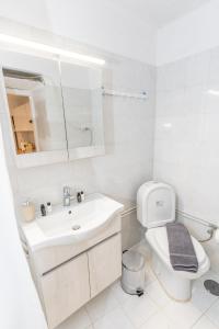 a white bathroom with a sink and a toilet at Syros DouBleTS rooms in Ermoupoli