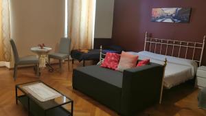 una sala de estar con un sofá y una cama en Affittacamere Guerrero JR Tra storia e cultura, en Trieste