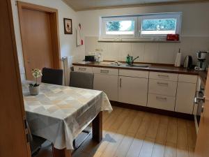 a kitchen with a table and a sink and a window at Ferienhof Schräder "Ol Deele" in Papenburg