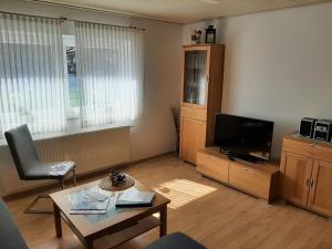 a living room with a television and a table at Ferienhof Schräder "Ol Deele" in Papenburg