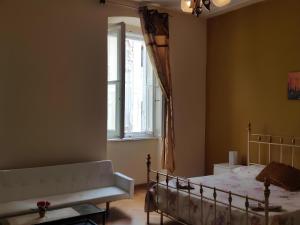 Un dormitorio con una cama y un sofá y una ventana. en Affittacamere Guerrero JR Tra storia e cultura, en Trieste 13 fotos más