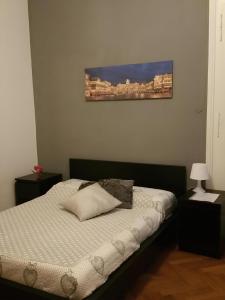 1 dormitorio con 1 cama con una foto en la pared en Affittacamere Guerrero JR Tra storia e cultura, en Trieste