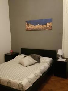 Un dormitorio con una cama con un cuadro en la pared. en Affittacamere Guerrero JR Tra storia e cultura, en Trieste