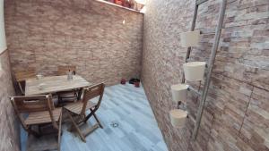 a dining room with a table and a brick wall at Tahona in Carmona +4 photos