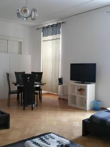 Una sala de estar con una mesa y sillas y un televisor. en Affittacamere Guerrero JR Tra storia e cultura, en Trieste