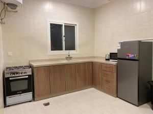 a kitchen with a stove and a refrigerator at نايتس للوحدات المفروشة in Tabuk