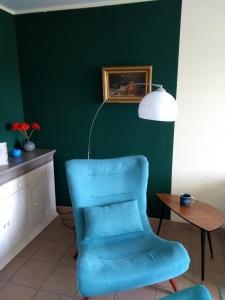 a blue chair in a room with a green wall at Ostseeresidenz - Whg 14 in Zingst