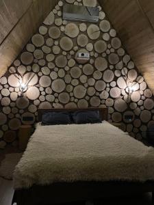 um quarto com uma cama com uma parede feita de troncos em SweeDom Shale em Almaty