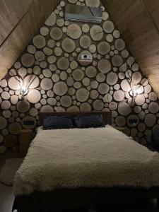 a bedroom with a bed with a wall made of logs at SweeDom Shale in Almaty