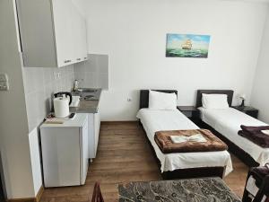um pequeno quarto com 2 camas e uma cozinha em Apartments Kuca Aleksic em Niš