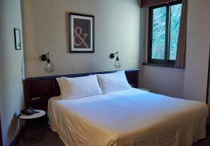 1 dormitorio con 1 cama grande con sábanas blancas en Hotel Concorde, en Arona