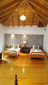 a bedroom with two beds and a stone wall at Stone home Lyhna in Líkhna