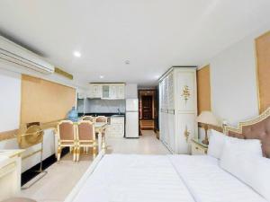 1 Schlafzimmer mit einem weißen Bett und einer Küche in der Unterkunft Sai Gon Hotel Bui Vien Walking Street in Ho-Chi-Minh-Stadt