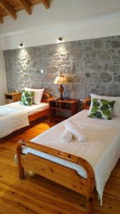 a bedroom with two beds and a stone wall at Stone home Lyhna in Líkhna