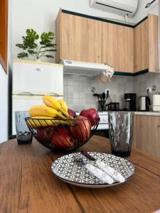 a bowl of fruit on a table with a plate at Aesthetic Cozy Haven in Kremasti +18 photos