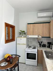 a kitchen with a white stove and a table at Aesthetic Cozy Haven in Kremasti