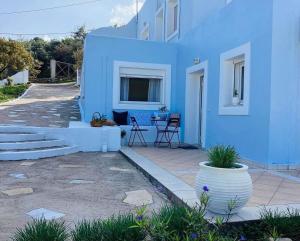 une maison bleue avec une terrasse en face de celle-ci dans l'établissement The Blue House, à Vromolithos