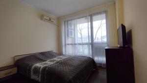 um quarto com uma cama e uma janela com uma televisão em Apartment_Villa Astoria 3 em Elenite