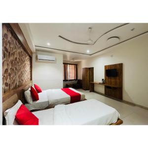 a hotel room with two beds and a television at hotel hill city in Gandhinagar