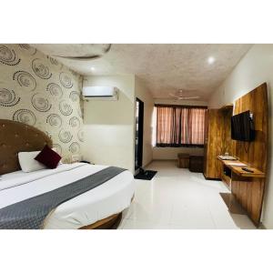 a bedroom with a bed and a television in it at hotel hill city in Gandhinagar