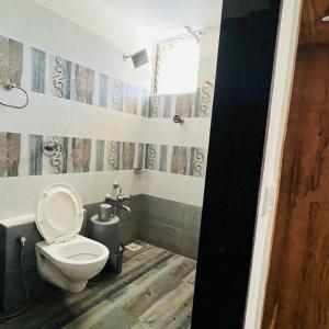 a small bathroom with a toilet and a window at hotel hill city in Gandhinagar