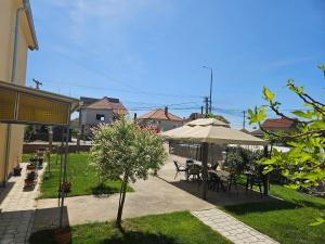 um pátio com mesas e cadeiras e um guarda-sol em Apartments Kuca Aleksic em Niš