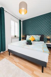 a bedroom with a large bed with green walls at Smart Home - Wuppertal - Perfect for 6 Guests - Central - Netflix - Schwebebahn - Free Parking Zone in Wuppertal