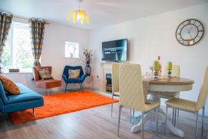 sala de estar con mesa, sillas y TV en Bomaquarters COSY AND LUXURIOUS 2 BED VILLIERS HOUSE en Coventry