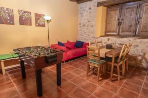 a living room with a table and a red couch at La Hacendera Entre Hoces - 20-28pax-10 hab con baños en suite in Maderuelo