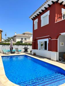 a villa with a swimming pool in front of a house at Casa Gemela in Torre-Pacheco