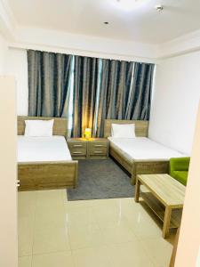um quarto de hotel com duas camas e um sofá em Wonderful Master Rooms For Girls ONLY in Marina, Dubai no Dubai