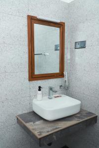 uma casa de banho com um lavatório branco e um espelho. em Airport Colombo Pocket Paradise em Seeduwa