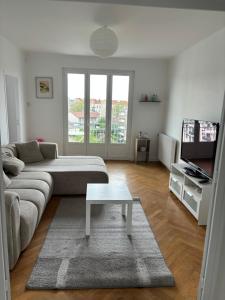 a living room with a couch and a coffee table at Appartement des merveilles in Vénissieux