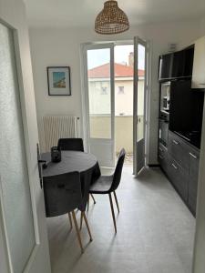 eine Küche und ein Esszimmer mit einem Tisch und Stühlen in der Unterkunft Appartement des merveilles in Vénissieux