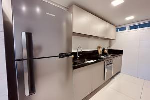 a kitchen with a refrigerator and a sink at Lindo Apto 2 quartos no Solar Tambaú in João Pessoa