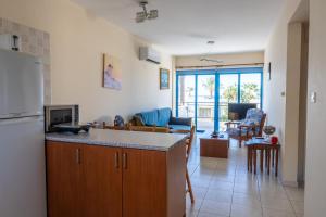 a kitchen and a living room with a refrigerator at Arsinoe Beach Village Block 9 in Polis Chrysochous