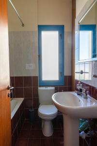 a bathroom with a toilet and a sink and a window at Arsinoe Beach Village Block 9 in Polis Chrysochous