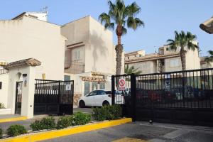 un'auto bianca parcheggiata davanti a un edificio con un cancello di Lovely Holiday Home Santa Pola,Gran Alacant a Gran Alacant