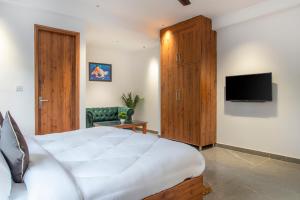 een slaapkamer met een groot bed en een televisie bij Kasauli Mountain Hills I Kasauli I vacation in Kasauli