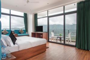 een slaapkamer met een groot bed en een balkon bij Kasauli Mountain Hills I Kasauli I vacation in Kasauli