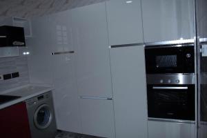 a kitchen with white cabinets and a washer and dryer at Luxe Isle by Harolty, East Legon in Accra