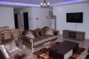 a living room with a couch and a table at Luxe Isle by Harolty, East Legon in Accra
