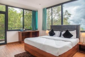 een slaapkamer met een groot bed en grote ramen bij Kasauli Mountain Hills I Kasauli I vacation in Kasauli