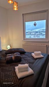 ein Schlafzimmer mit 2 Betten und Handtüchern darauf in der Unterkunft Apart Ali with parking in Zărneşti