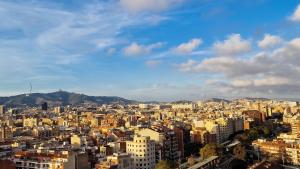 a view of a city with buildings and mountains at Touch the Sky in Hospitalet de Llobregat