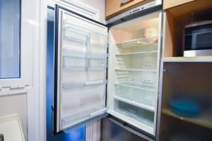 un frigorifero vuoto con la porta aperta in una cucina di Touch the sky BCN a Hospitalet de Llobregat