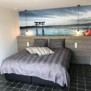 uma cama num quarto com vista para o oceano em Vakantiewoning de Worfthoeve em Geel
